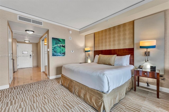 bedroom featuring ornamental molding, light colored carpet, visible vents, and baseboards