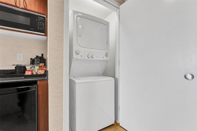 laundry area with light tile patterned floors, laundry area, and stacked washer / drying machine