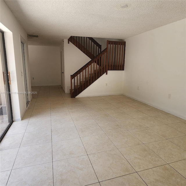 4149 Wimbledon Dr Unit 4149, Cooper City, FL 33026 - spare room featuring a textured ceiling, stairway, and light tile patterned floors