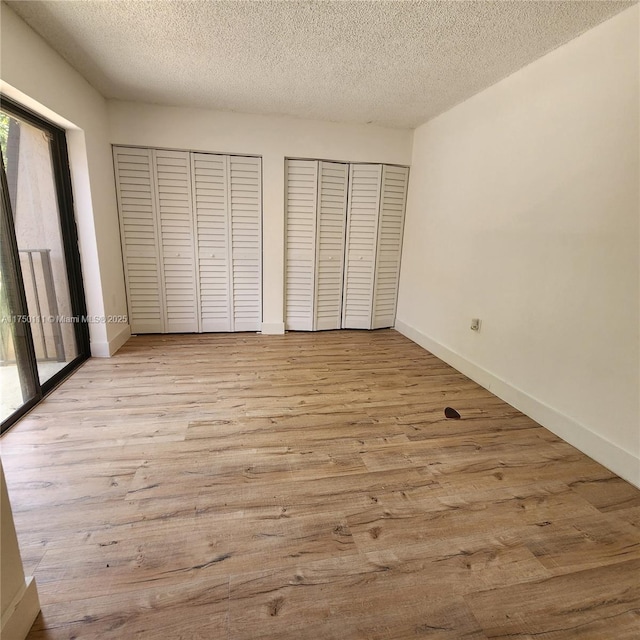 4149 Wimbledon Dr Unit 4149, Cooper City, FL 33026 - unfurnished bedroom featuring two closets, wood finished floors, a textured ceiling, and baseboards