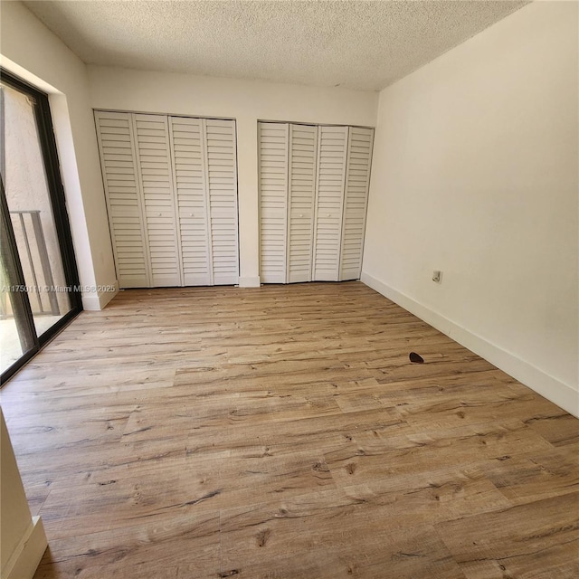 4149 Wimbledon Dr Unit 4149, Cooper City, FL 33026 - unfurnished bedroom featuring two closets, a textured ceiling, wood finished floors, and baseboards
