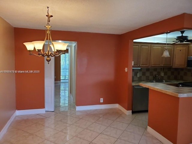 kitchen with backsplash, stainless steel appliances, light countertops, pendant lighting, and a sink