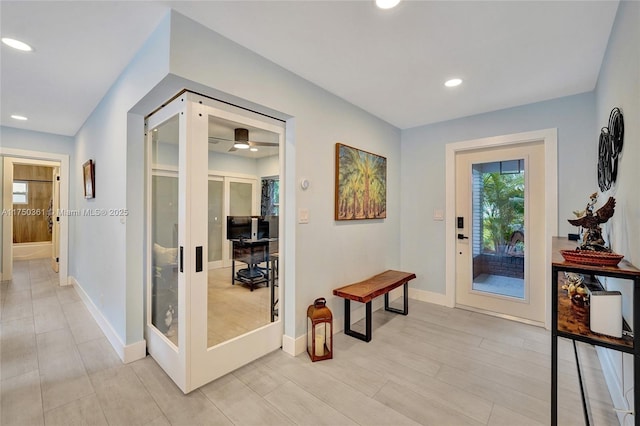 corridor featuring light wood-style floors, recessed lighting, french doors, and baseboards