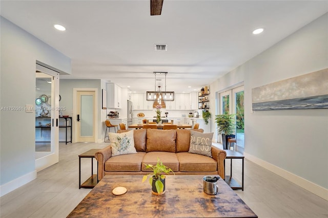 living room featuring recessed lighting, baseboards, visible vents, and french doors