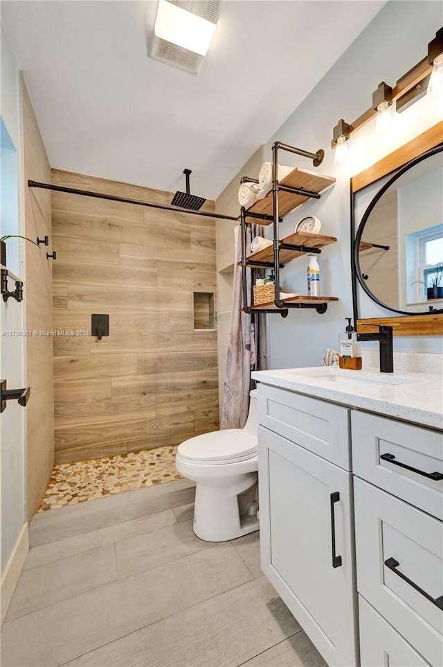 full bathroom with toilet, a stall shower, and vanity