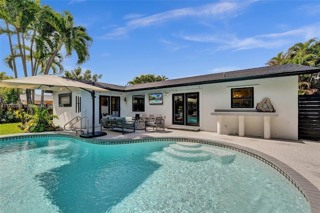 rear view of house featuring an outdoor pool, fence, a patio area, an outdoor living space, and stucco siding