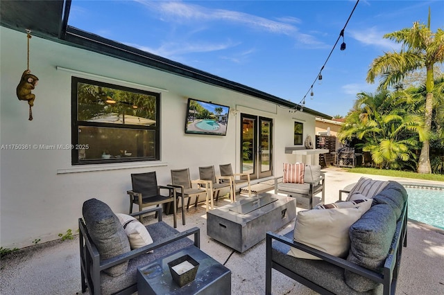 view of patio / terrace featuring an outdoor living space with a fire pit and an outdoor pool