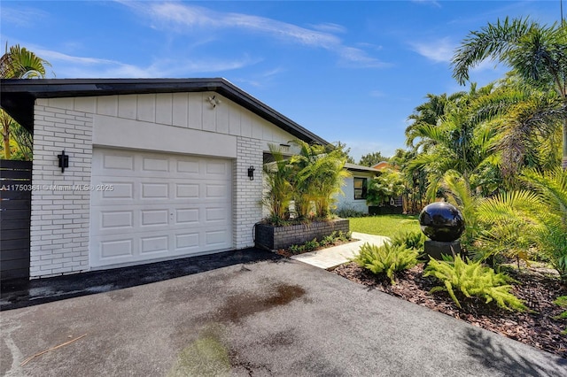 exterior space featuring brick siding, driveway, and an attached garage