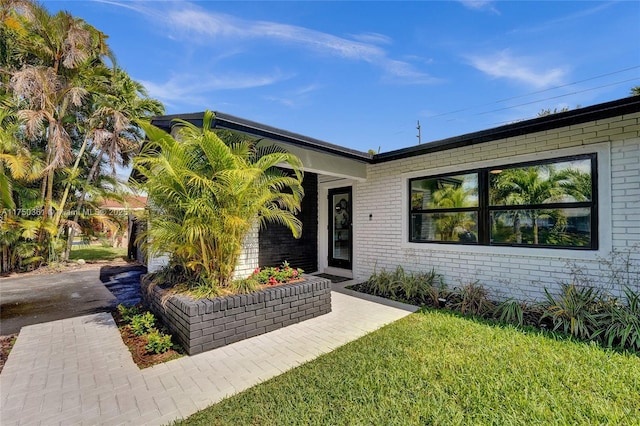 view of front of property featuring brick siding and a front yard