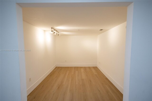 495 Brickell Ave Unit 2102, Miami, FL 33131 - hallway featuring light wood-type flooring, rail lighting, visible vents, and baseboards