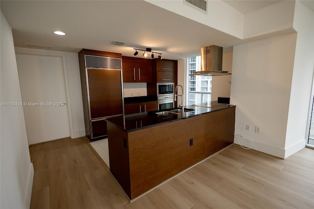 495 Brickell Ave Unit 2102, Miami, FL 33131 - kitchen with dark countertops, visible vents, paneled built in refrigerator, a peninsula, and extractor fan