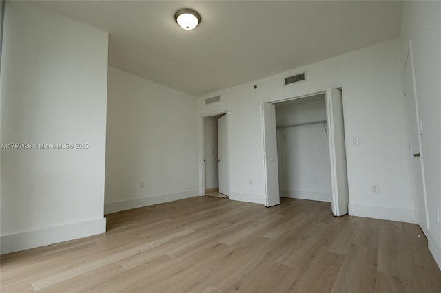 495 Brickell Ave Unit 2102, Miami, FL 33131 - unfurnished bedroom with light wood-style flooring, a closet, visible vents, and baseboards