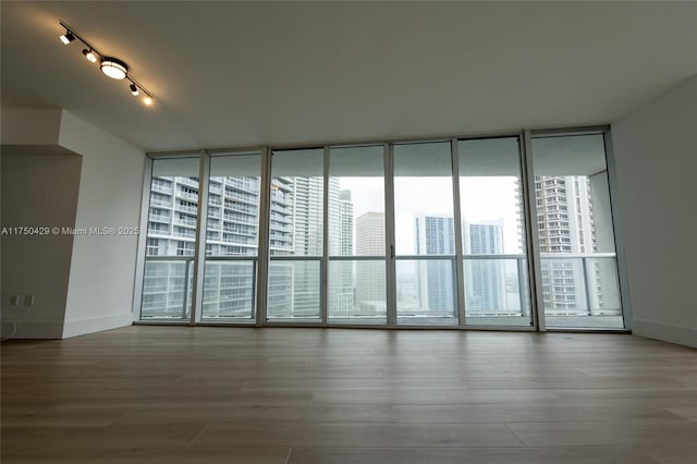 495 Brickell Ave Unit 2102, Miami, FL 33131 - empty room with a view of city, expansive windows, and wood finished floors