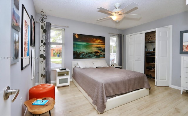 bedroom with light wood finished floors, baseboards, and a closet