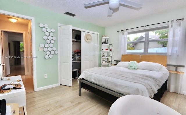 bedroom with light wood finished floors, a closet, visible vents, and baseboards