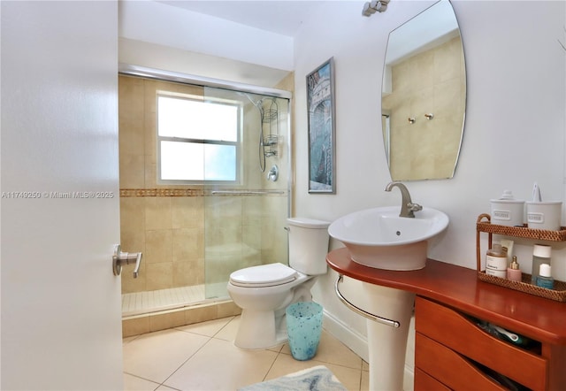 full bath featuring a stall shower, tile patterned flooring, a sink, and toilet