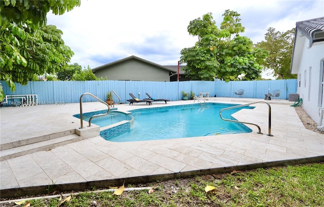 view of swimming pool with central air condition unit, a fenced backyard, a pool with connected hot tub, and a patio