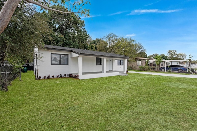 view of front of home featuring fence, a front lawn, concrete driveway, and stucco siding