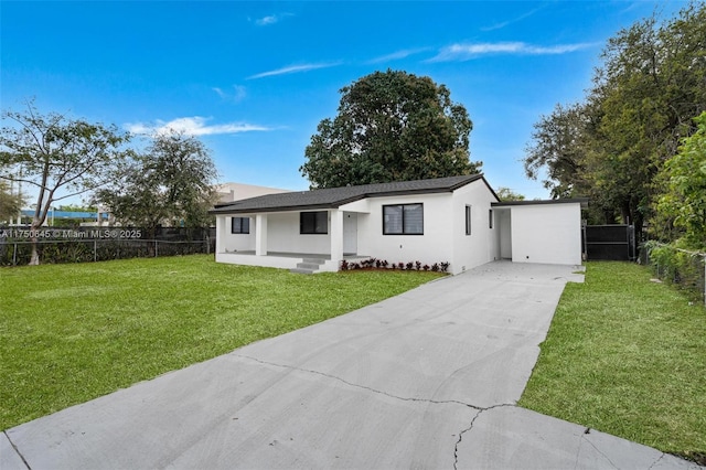 view of front of home featuring driveway, a front lawn, fence, and stucco siding