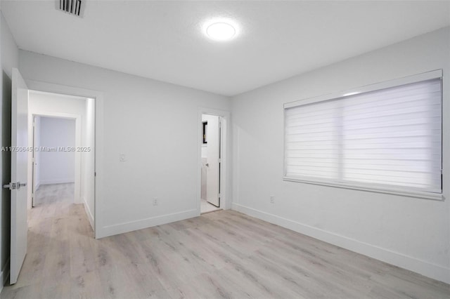 unfurnished bedroom with light wood-style flooring, visible vents, and baseboards