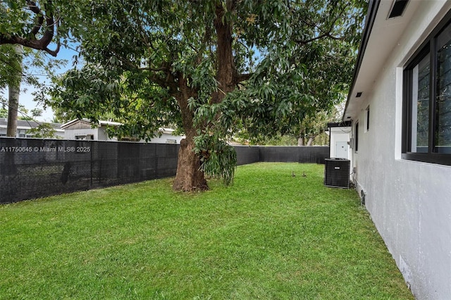 view of yard featuring central AC and a fenced backyard