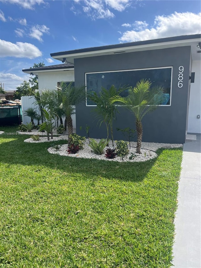 view of side of home featuring a yard and stucco siding