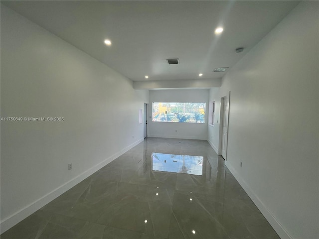 empty room featuring recessed lighting, marble finish floor, visible vents, and baseboards