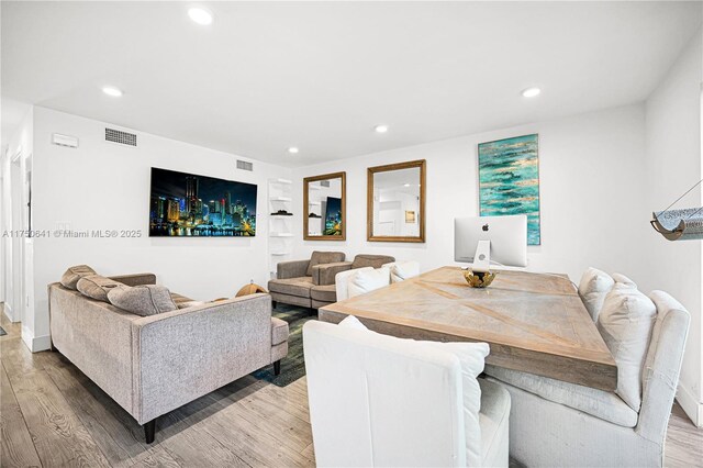 living area with light wood finished floors, visible vents, and recessed lighting