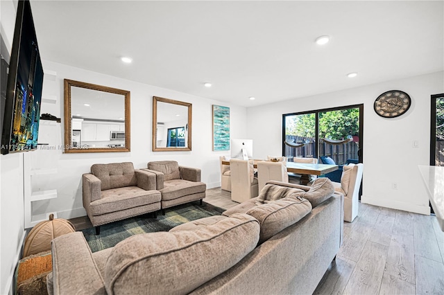 living room with light wood-style flooring, baseboards, and recessed lighting