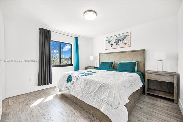 bedroom featuring light wood-type flooring and baseboards