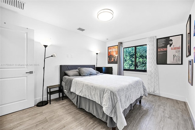 bedroom with light wood finished floors, baseboards, and visible vents