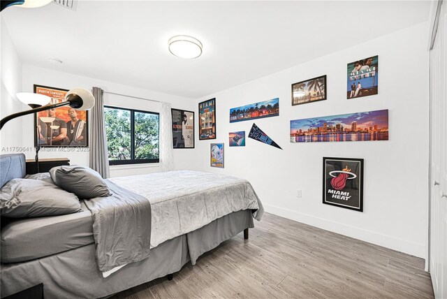 bedroom with light wood-type flooring and baseboards