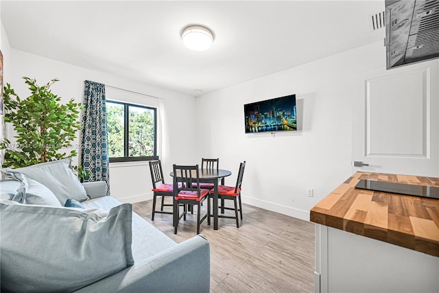 dining room with visible vents, light wood-style flooring, and baseboards