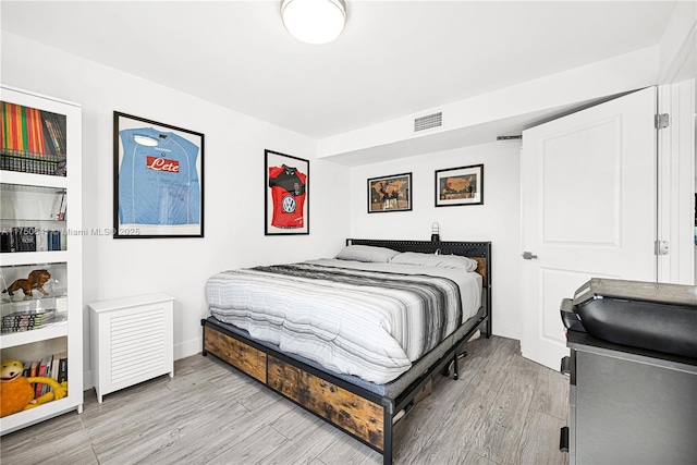 bedroom featuring baseboards, visible vents, and light wood-style floors