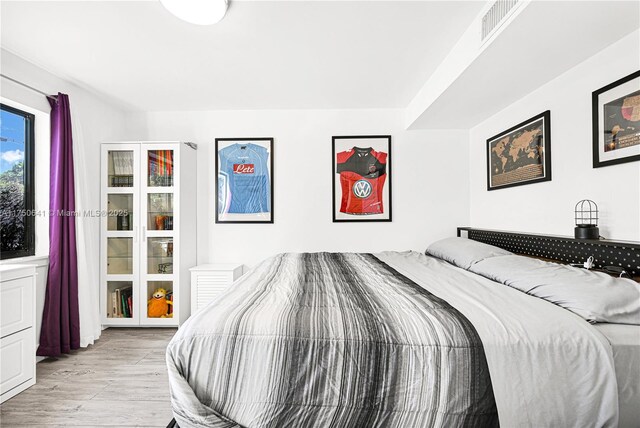 bedroom with light wood-type flooring and visible vents