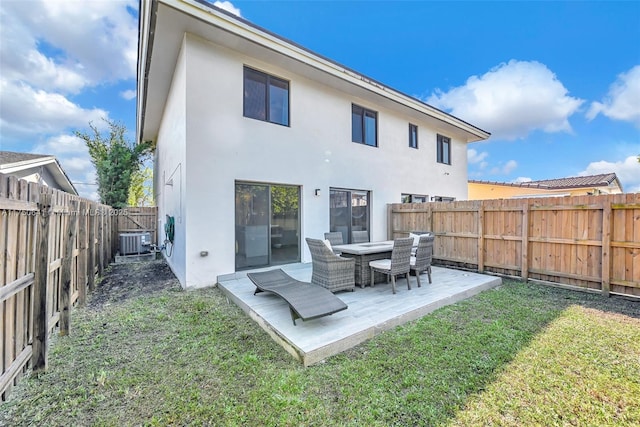 rear view of house featuring a yard, a patio area, a fenced backyard, and stucco siding