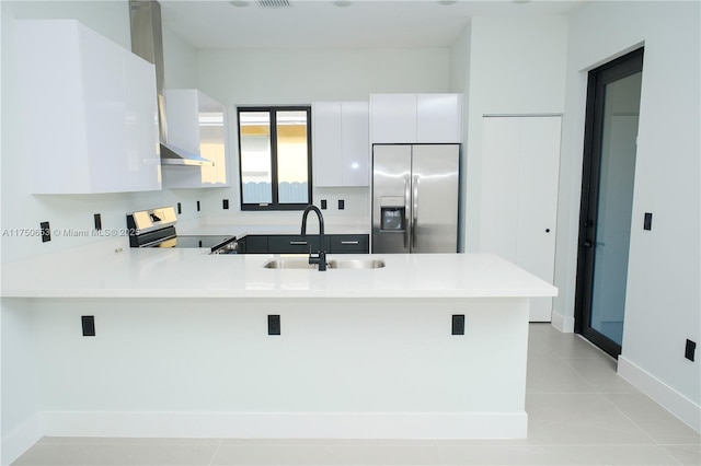 kitchen featuring a peninsula, appliances with stainless steel finishes, a sink, and light countertops