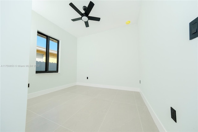 spare room featuring light tile patterned floors, ceiling fan, and baseboards