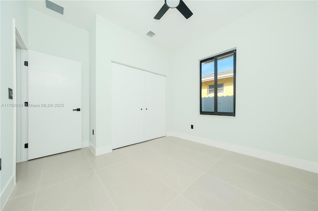 unfurnished bedroom featuring baseboards, visible vents, ceiling fan, a closet, and light tile patterned flooring