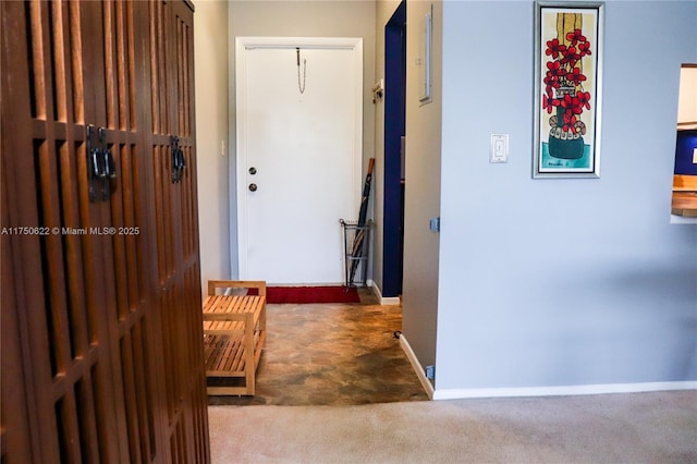 hallway featuring carpet flooring and baseboards