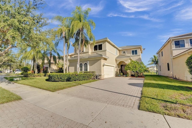 view of front facade with decorative driveway, a tile roof, stucco siding, a garage, and a front lawn