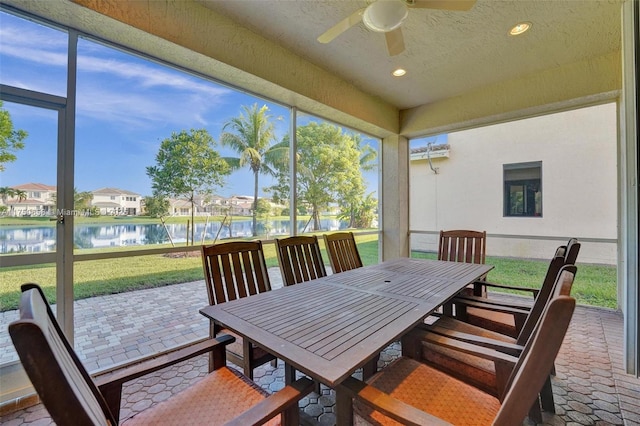 sunroom featuring a water view, ceiling fan, and an AC wall unit