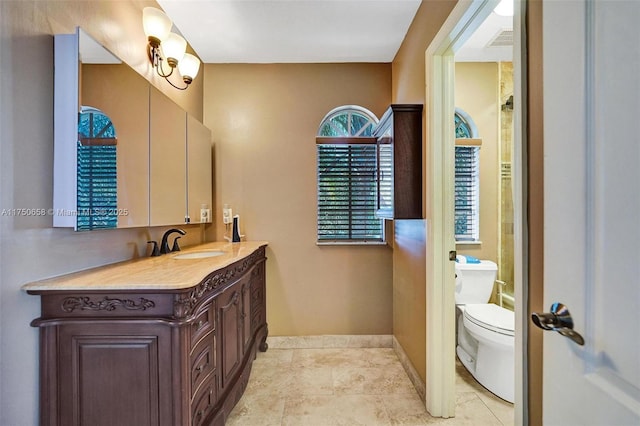 full bath featuring toilet, baseboards, visible vents, and vanity