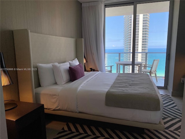 bedroom featuring a water view and wallpapered walls