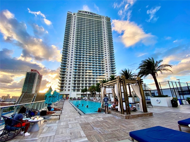 view of swimming pool featuring a patio area and a view of city