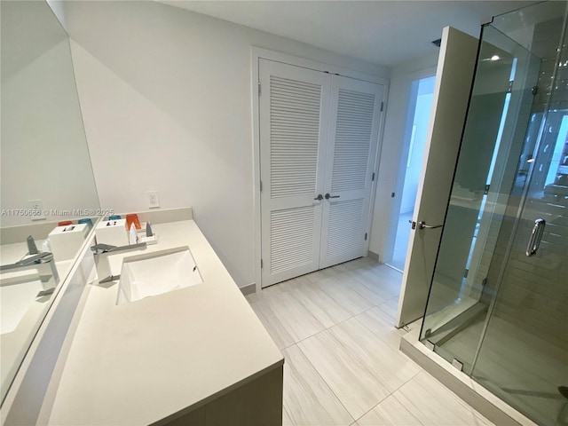 bathroom featuring a closet, vanity, and a shower stall