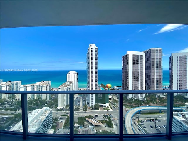 balcony featuring a water view and a city view