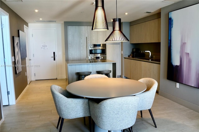 dining area with light wood-type flooring, baseboards, visible vents, and recessed lighting