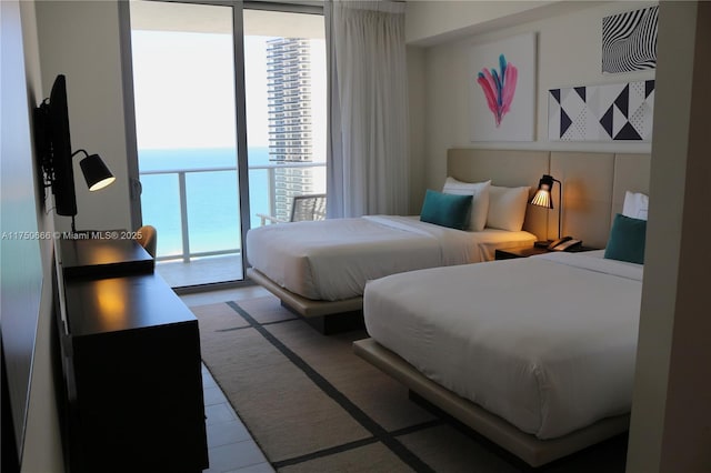 bedroom featuring a water view and floor to ceiling windows