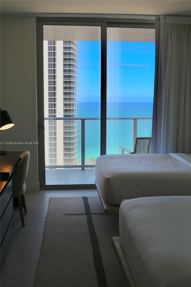 bedroom with a water view and wood finished floors